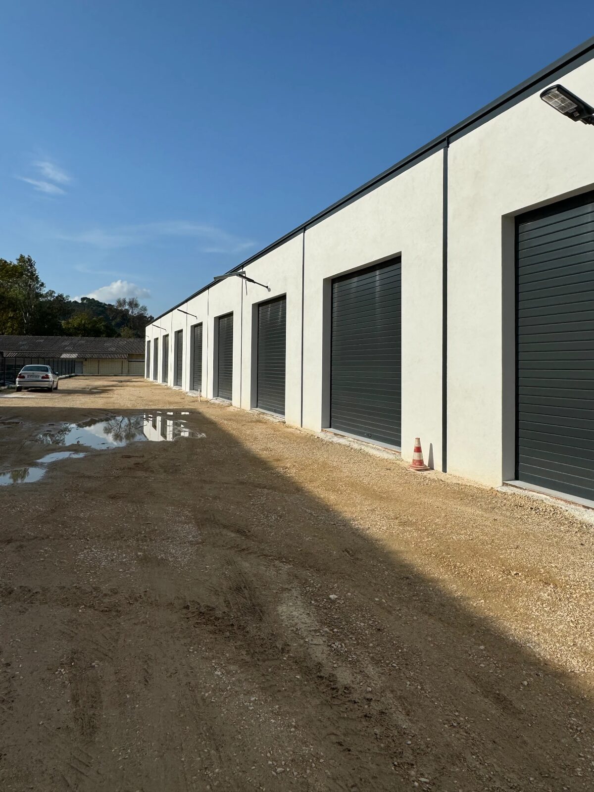 Façades enduites d'un bâtiment de locaux avec rideaux métalliques
