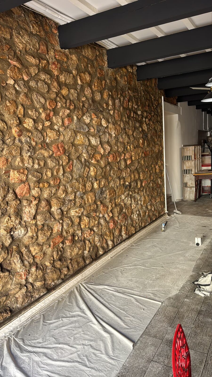 Mur en pierre apparente rejointoyé sous poutres apparentes